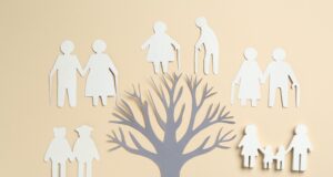 Family tree and cutouts on beige background, top view
